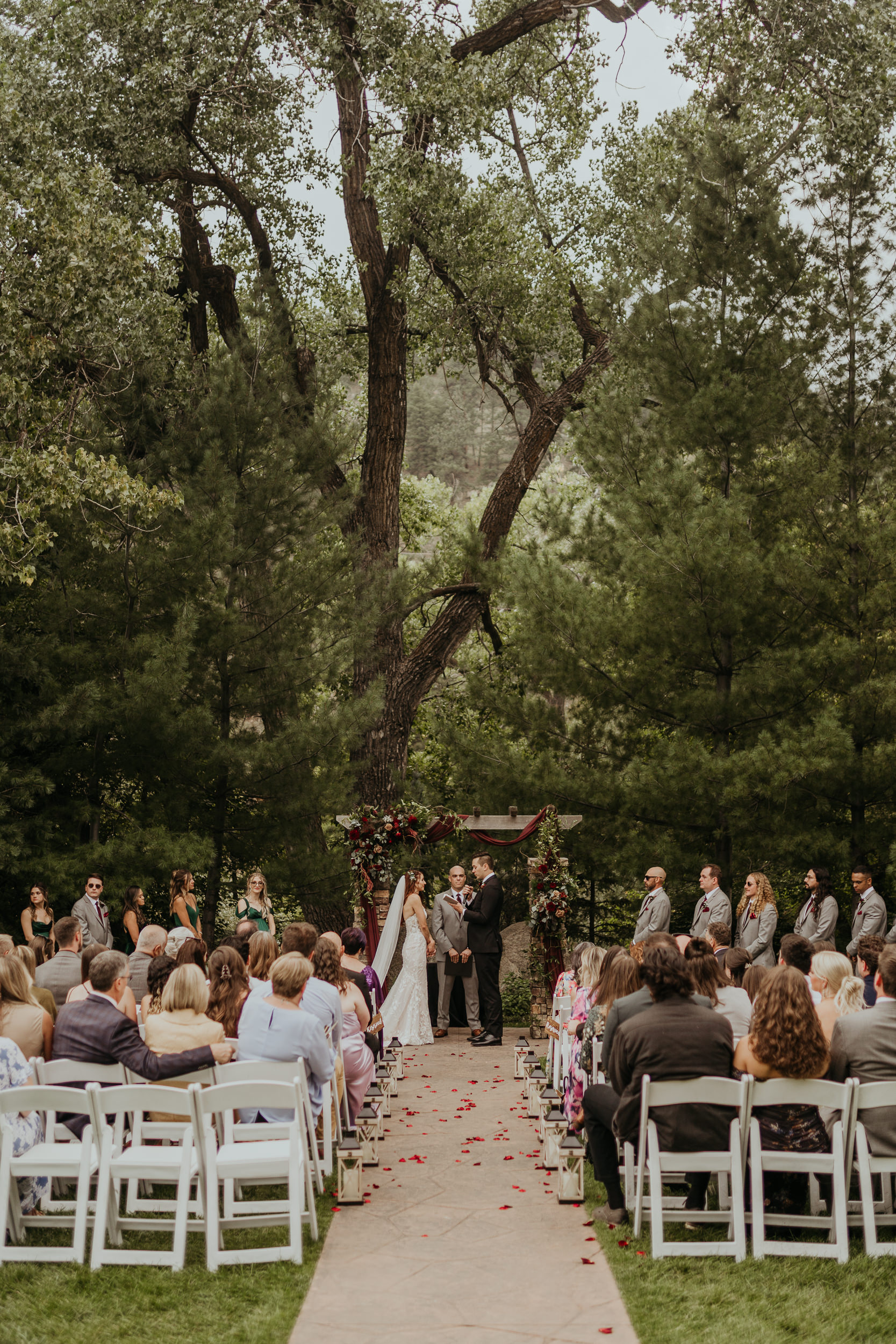 Ceremony at Boulder Creek by Wedgewood Weddings - couple standing in their cermony in front of all of their loved ones in front of a stunning tree