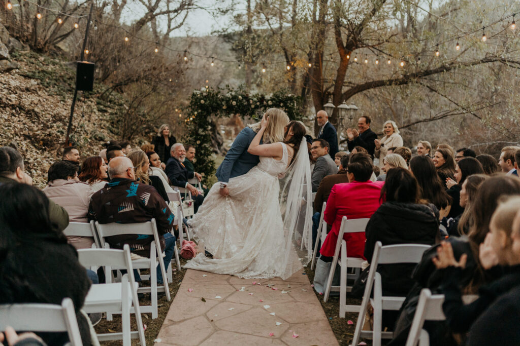 Couple doing a DIP while walking down the aisle right after they said I do at Boulder Creek by Wedgewood Weddings