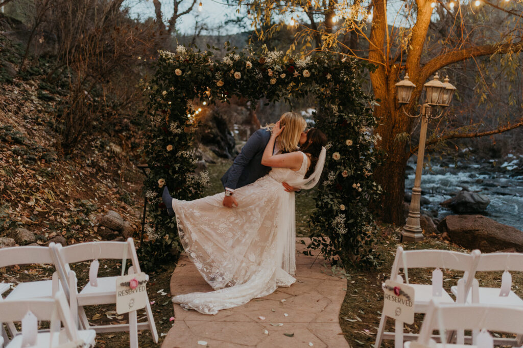 Couple doing a kiss and dip in their empty ceremony space at Boulder Creek by Wedgewood Weddings